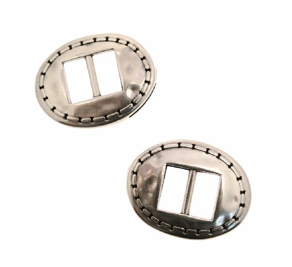 Chiusura per cordoncini o nastri piatti, effetto fibbia, forma ovale con decoro nel contorno, 32x25 mm.
