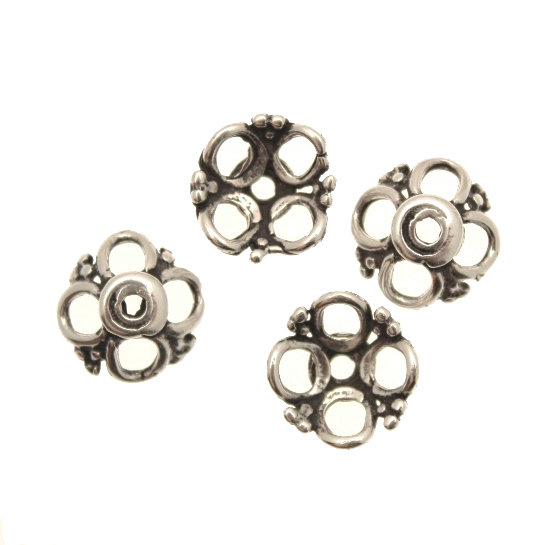 Coppetta tonda con quattro petali forati e decoro a palline tra i petali, diametro 13 mm.