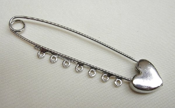 Spilla da balia con lavorazione in punta a cuore e 7 anelli 70 mm.