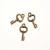 Ciondolo a forma di chiave corta mignon liscia 15x8 mm.